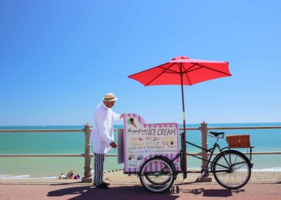 The English seaside: a gelato vendor with his old fashioned bicycle sets up for business on the seaside promenade at Hastings, in East Sussex